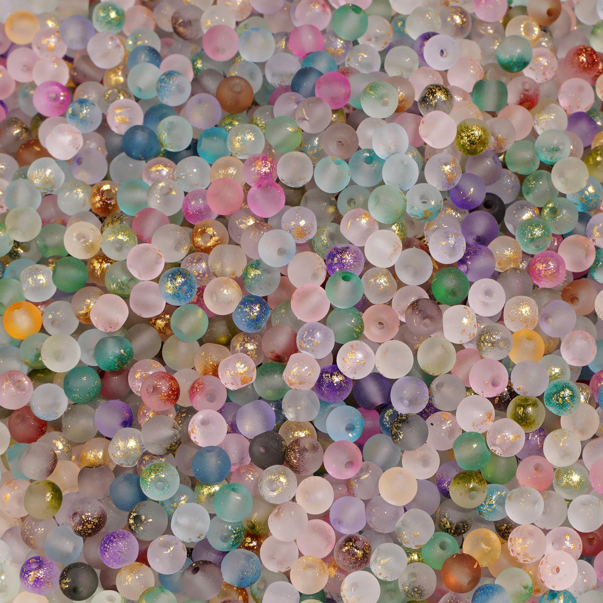 Set of 100 gold-splashed glass rice beads from Corporación Turística, 4mm, ideal for jewelry making or craft projects.