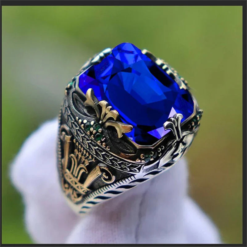 Luxury emerald ring with intricate inlay designs, featuring precious gemstone accents, designed for stylish wear on the shoulder.