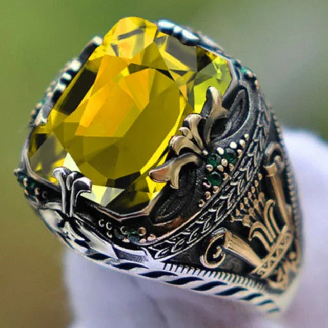 Luxury emerald ring with intricate inlay designs, showcasing a vibrant green gemstone and detailed craftsmanship.