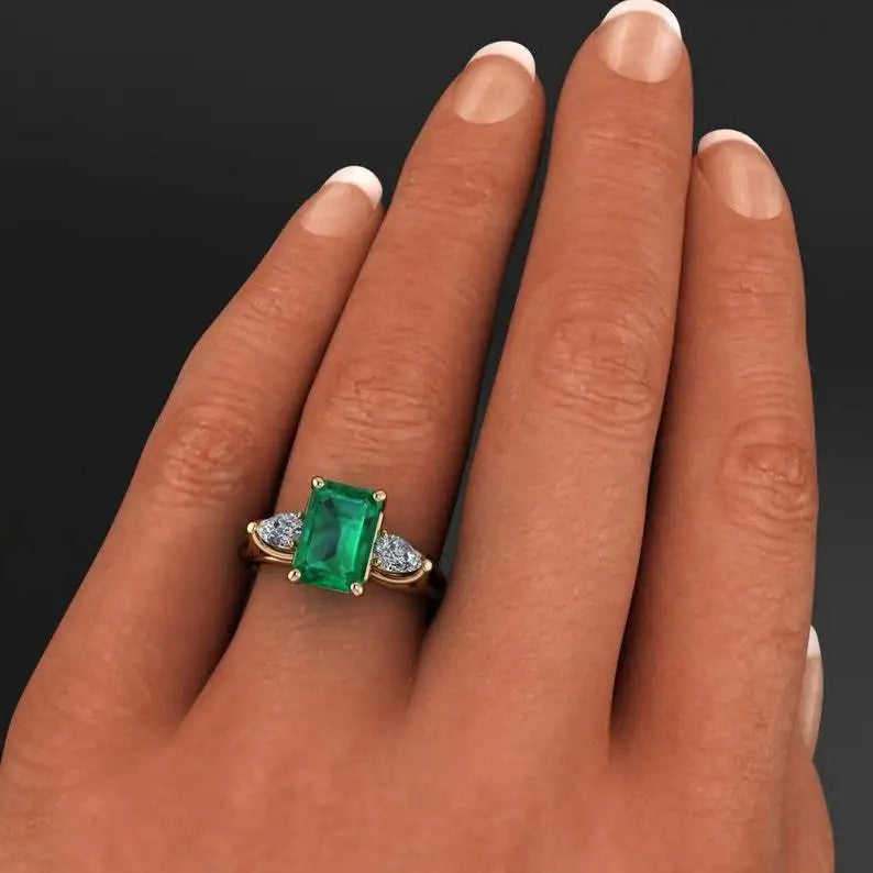 14k gold emerald ring for women featuring a vibrant green emerald gemstone and intricate gold band design.