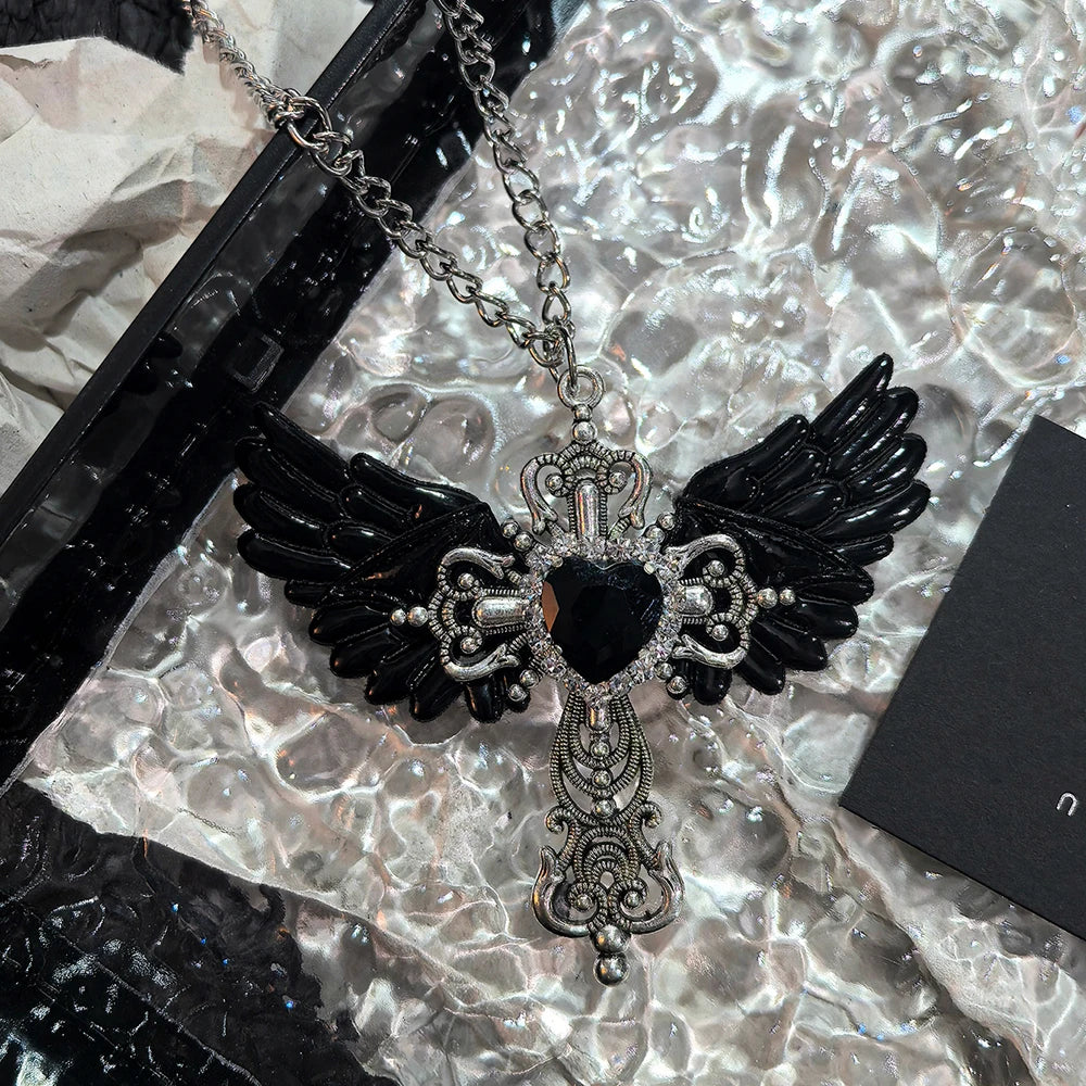 White Y2K-style collar with a heart and angel wing pendant, featuring silver-tone metal and intricate design details.
