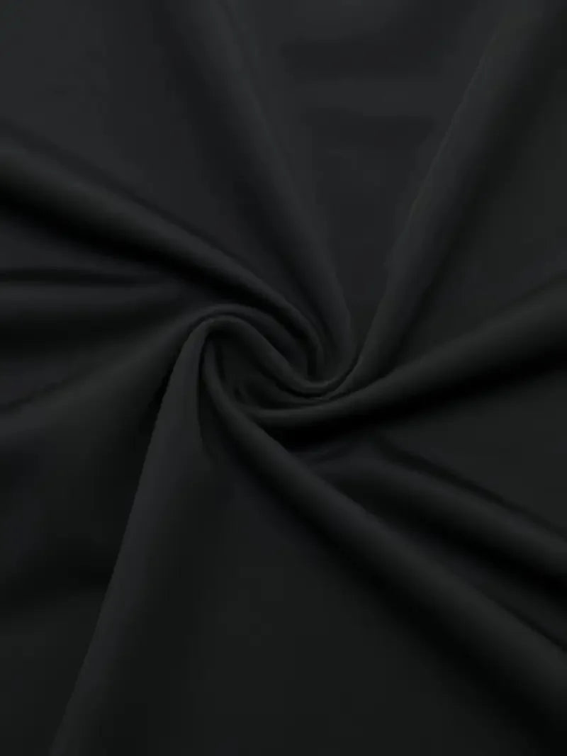 Close-up of a black long-sleeve fitted sports t-shirt with round neck by Corporación Turística, showing the fabric and fit.