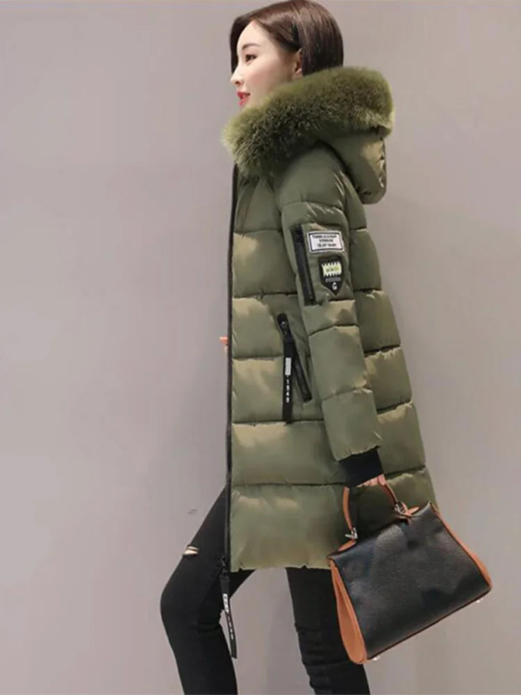 Black long winter coat for women with hood and high collar, from Corporación Turística, displayed on a hanger.