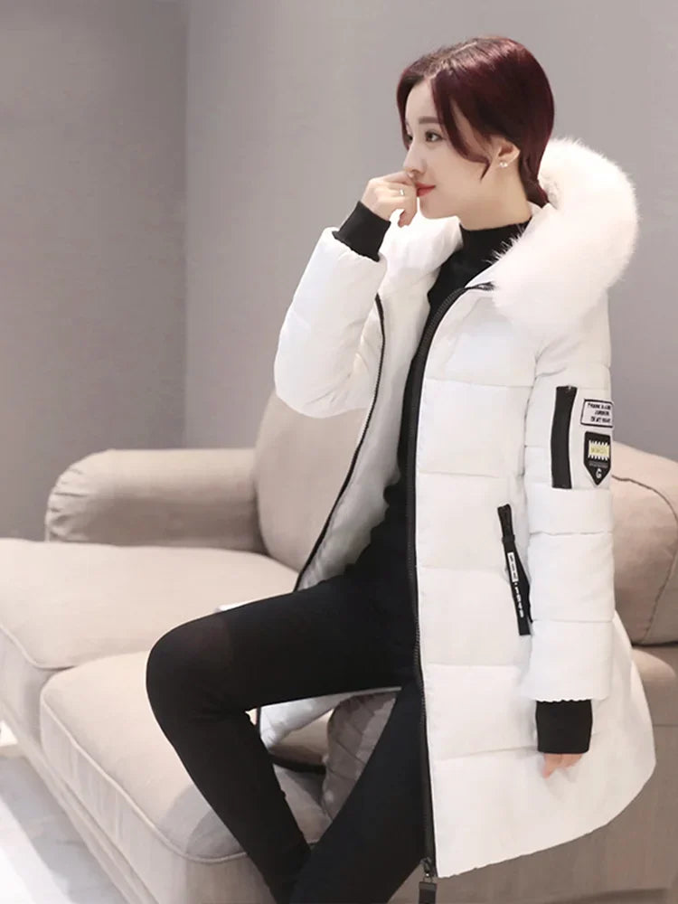 Long black women's winter coat with hood and high collar by Corporación Turística, shown on a mannequin.