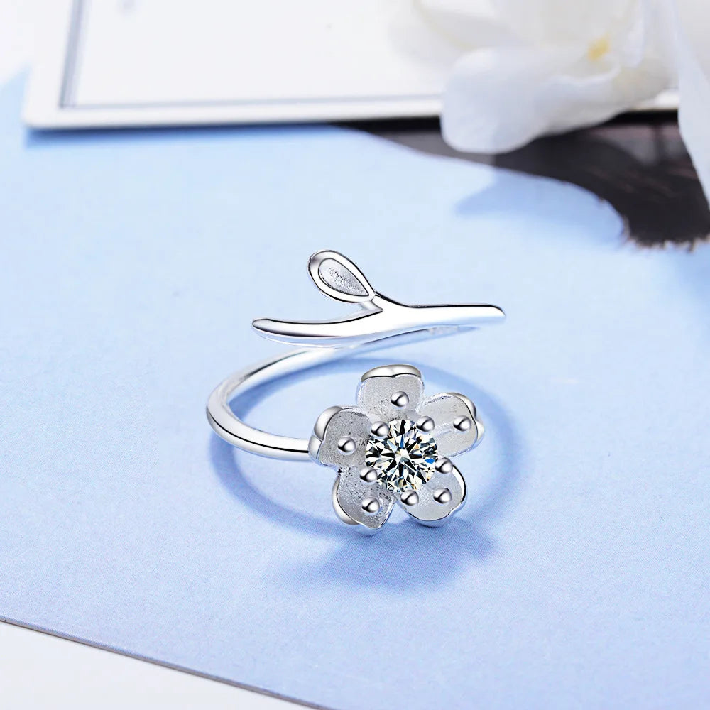 Sterling silver 925 ring with floral design and high-quality cubic zirconia, showcasing intricate flower details and sparkling stones.