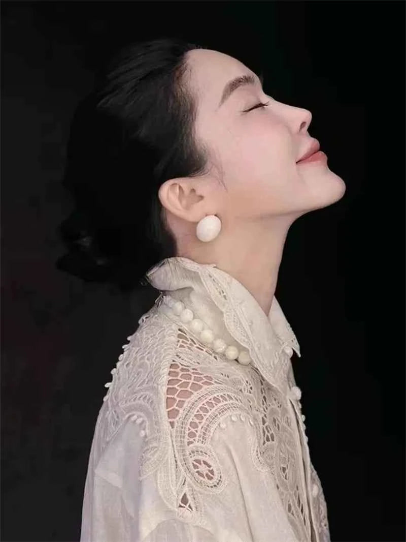 White embroidered floral blouse by Limiguyue featuring casual style, perfect for spring and summer, showcasing elegant French design.