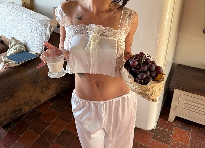 Two-piece top and pants set by Corporación Turística, featuring elegant lace details and a stylish, coordinated design.