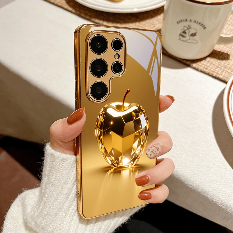 Golden fruit-shaped prism design phone case by Corporación Turística, showcasing vibrant, decorative fruit motifs on a sleek phone cover.