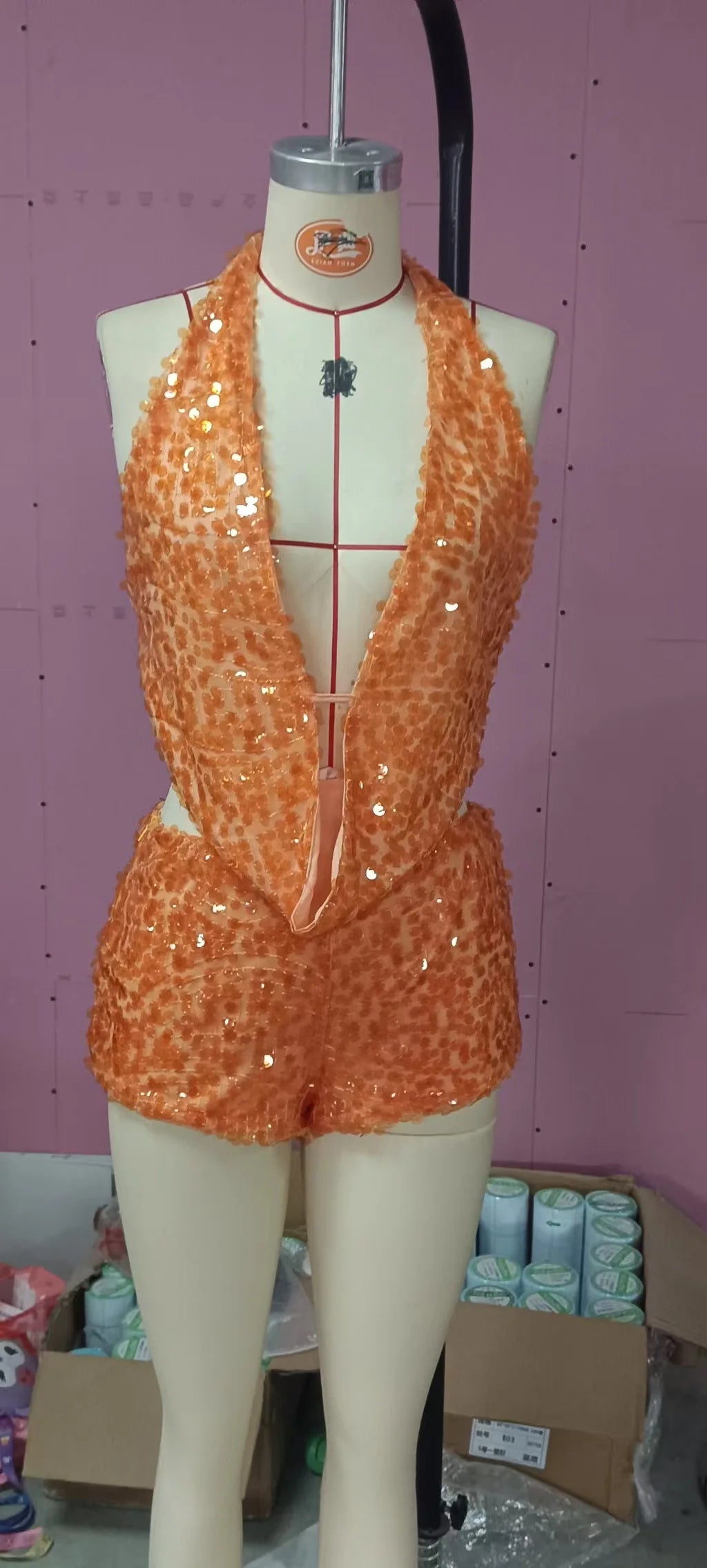 Two-piece sexy sequin set with sleeveless crop top and matching skirt, shiny gold fabric, designed by Corporación Turística.