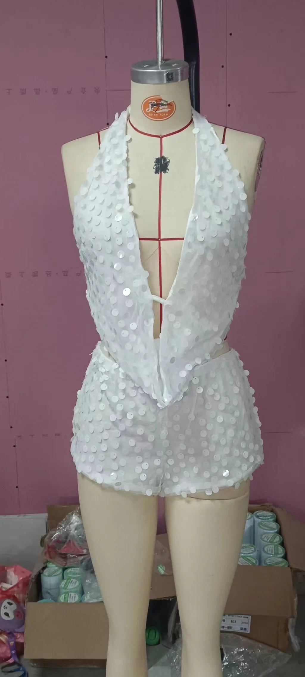 Two-piece sexy sequin crop top and skirt set from Corporación Turística, featuring shimmering silver sequins and sleeveless design.