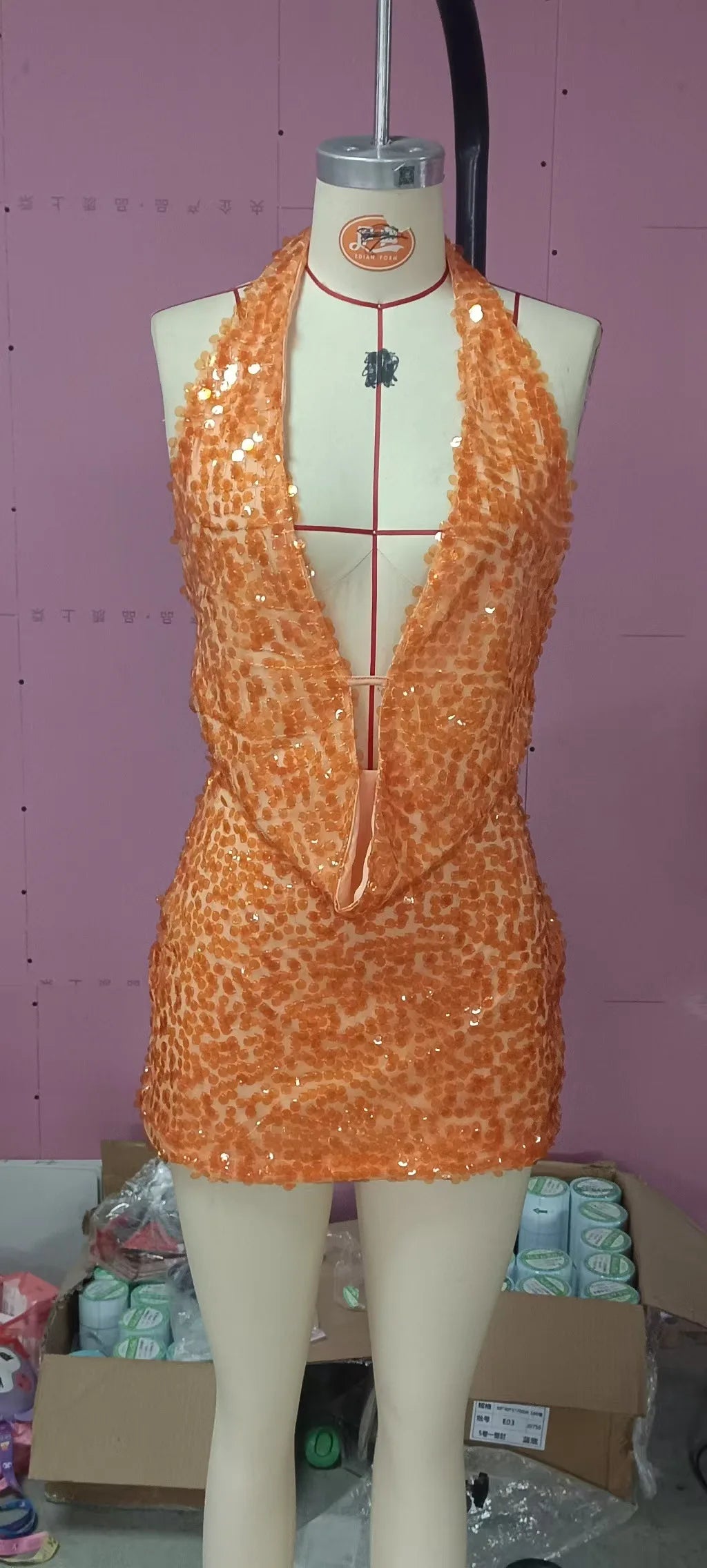 Sección de dos piezas de ropa sexy con lentejuelas, incluyendo un top sin mangas y pantalones, en color brillante y ajustados.