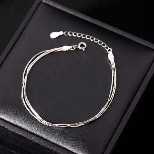 Sterling silver 925 bracelets for women and men, featuring sleek, minimalist designs, shown in a close-up image.