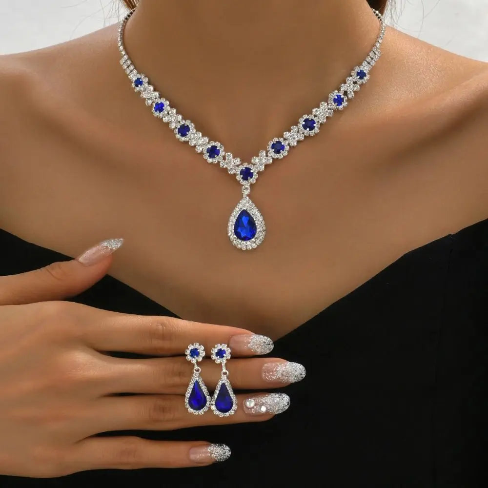 Elegant jewelry set with crystal pendant necklace and matching earrings from Corporación Turística, featuring sparkling crystal details.