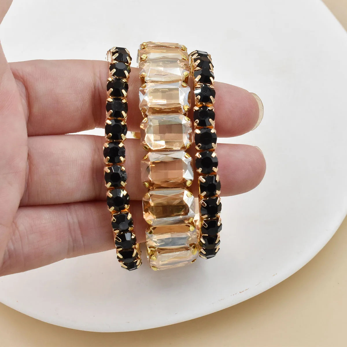 Set of three women's crystal bracelets featuring geometric designs, showcasing sparkling glass beads and elegant craftsmanship.