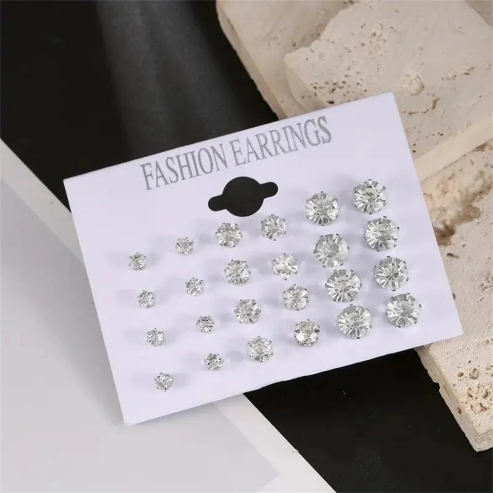 Set of 12 pairs of zirconia screw-back earrings by Corporación Turística, showcasing shiny silver-tone jewelry with secure clasps.