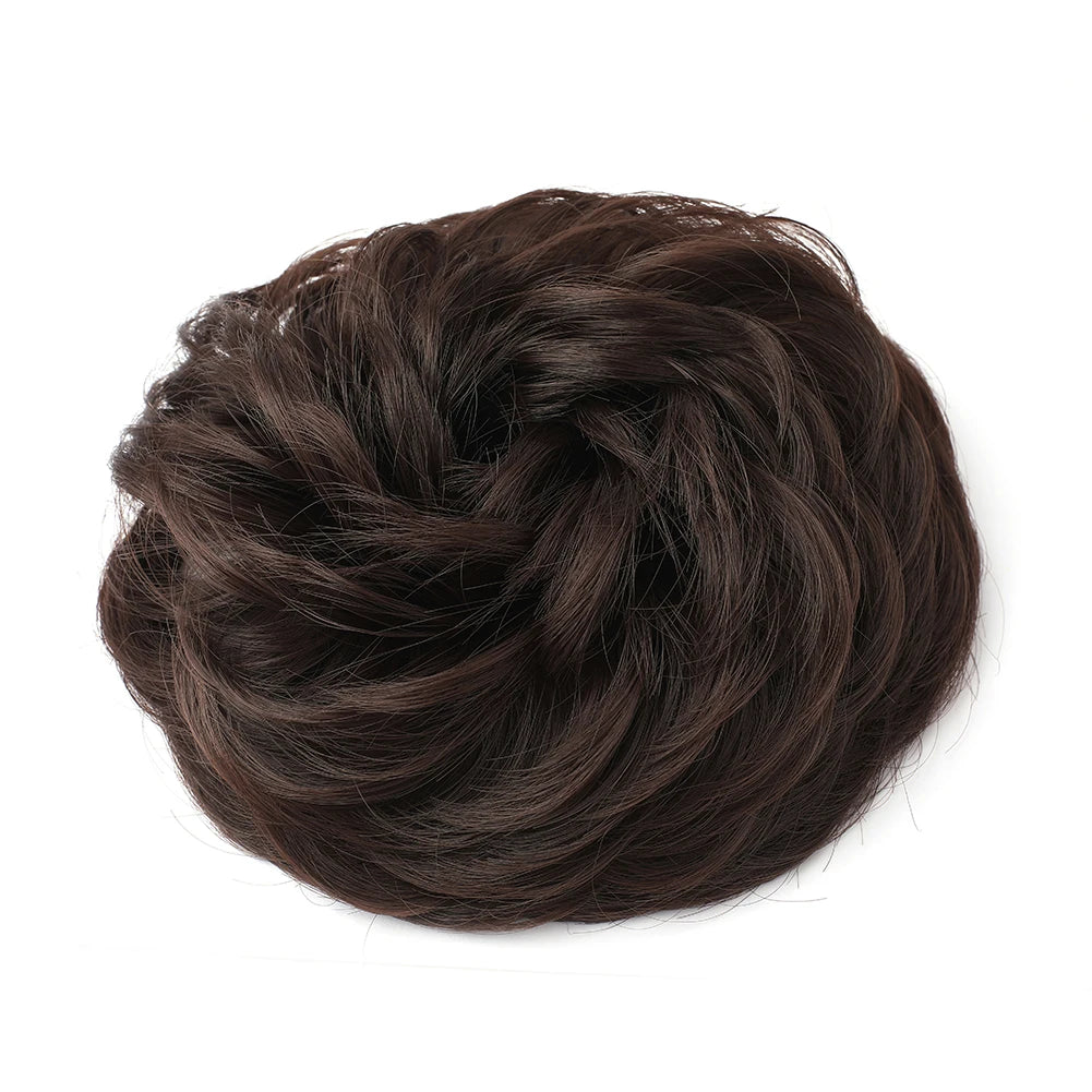 Large messy bun hairstyle featuring wavy and curly hair, created by Corporación Turística, shown in an image of a styled hairpiece.