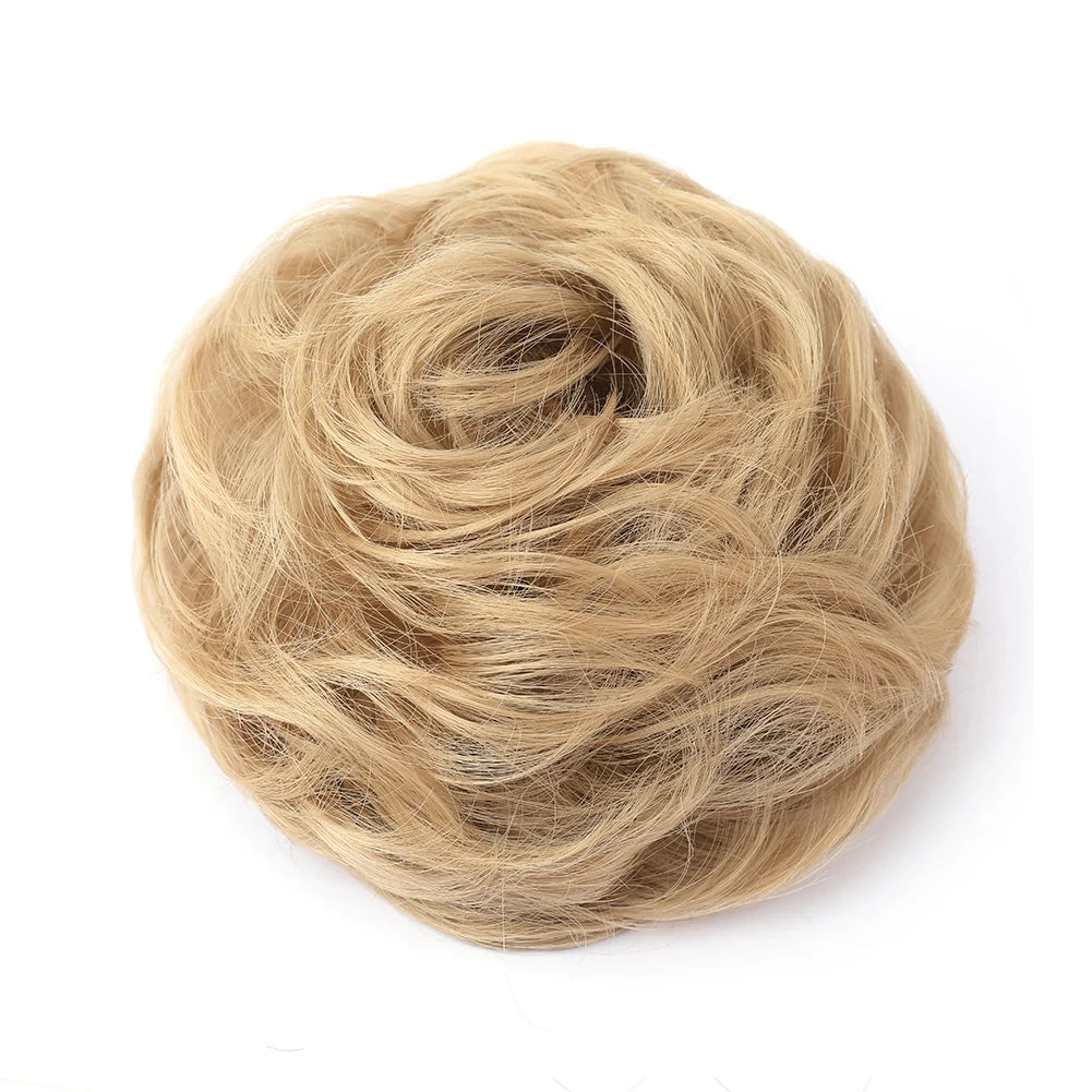 Large messy bun hairstyle featuring wavy and curly hair sections, styled by Corporación Turística with a tousled, voluminous look.