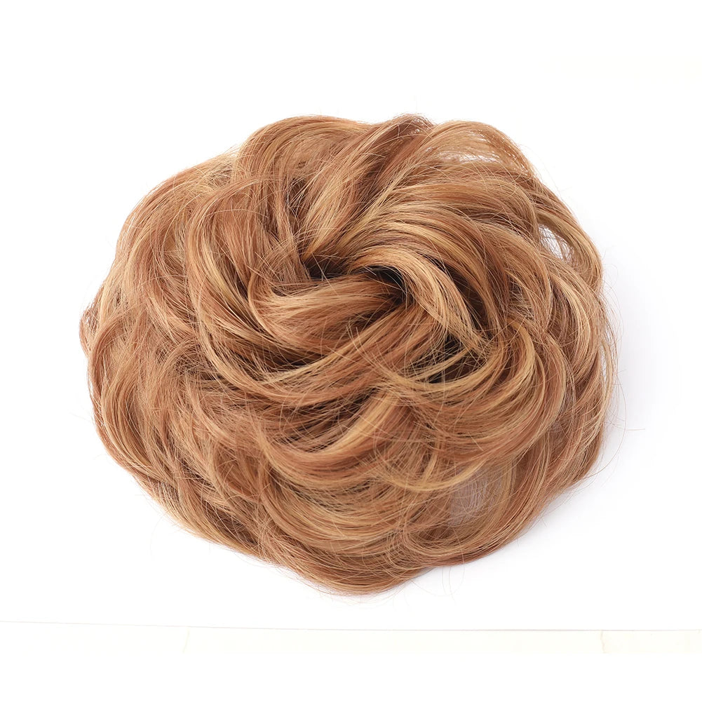 Large messy bun hairstyle with wavy and curly hair piece, created by Corporación Turística.