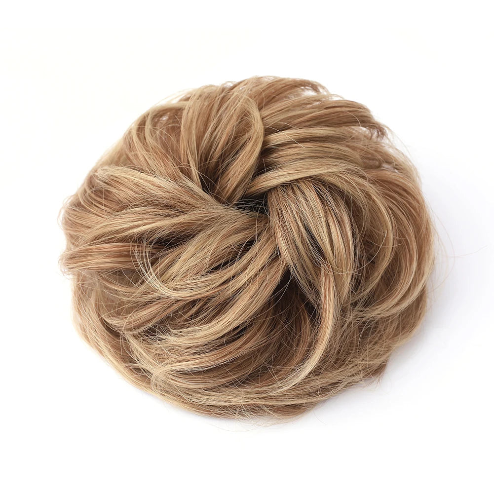 Large messy bun hairstyle with wavy, curly hair piece from Corporación Turística, showing a tousled, voluminous hairdo.