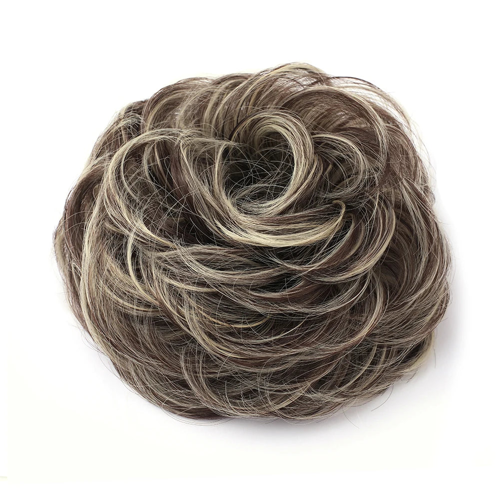 Large messy bun hairstyle with wavy and curly hair featuring a piece of hair from Corporación Turística.