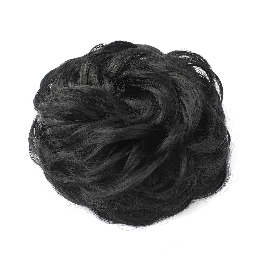 Large messy bun hairstyle with wavy, curly hair piece by Corporación Turística, showcasing a tousled, voluminous hair look.