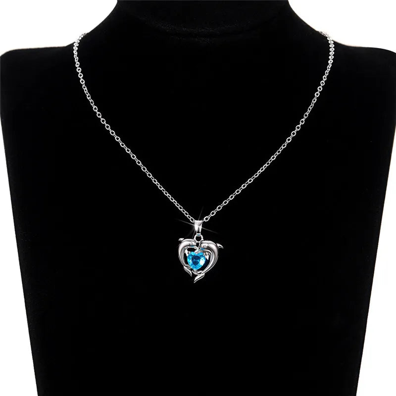 Sterling silver 925 dolphin and heart-shaped pendant necklace from Corporación Turística, featuring detailed ocean-inspired design.
