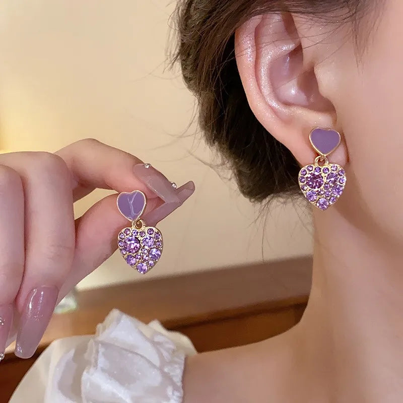 Purple crystal heart drop earrings for women, featuring elegant dangling design by Corporación Turística.