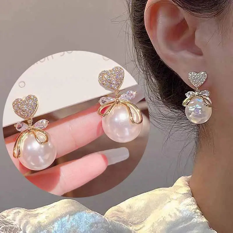Purple crystal heart drop earrings for women, elegant jewelry by Corporación Turística, featuring sparkling gemstone details.