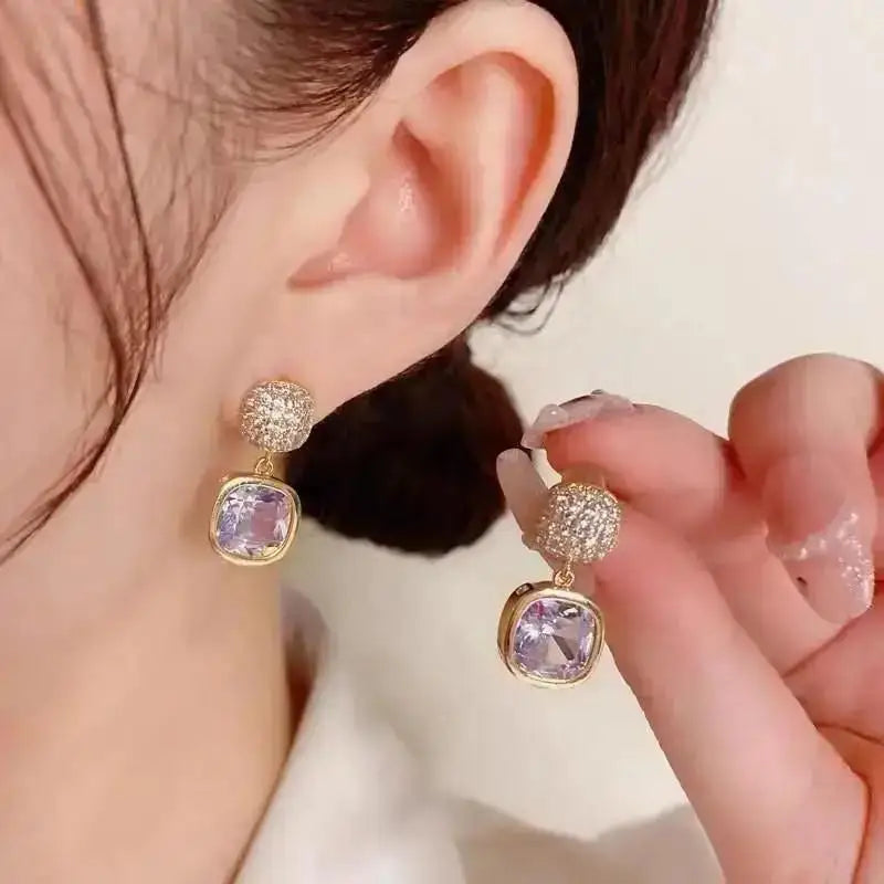 Purple crystal heart drop earrings for women, featuring elegant teardrop-shaped design by Corporación Turística.