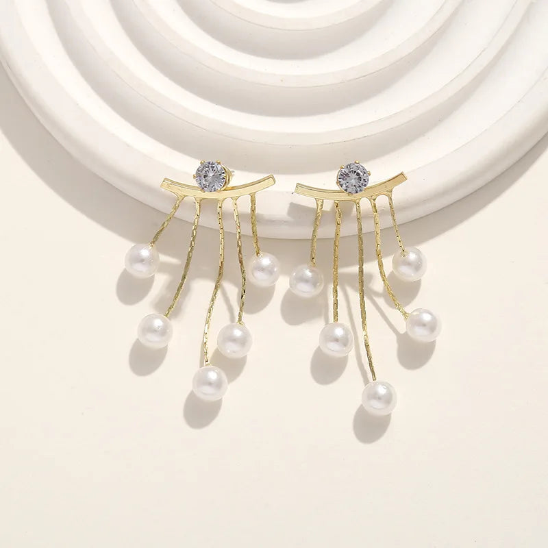 Korean fashion pearl tassel earrings with needle hook, featuring white pearl beads and elegant design, by Corporación Turística.