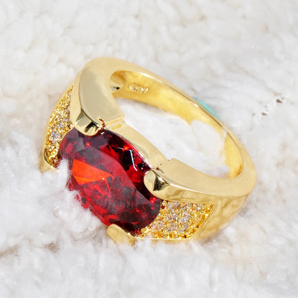 Red crystal ring with oval zirconia, luxurious jewelry piece from Corporación Turística featuring sparkling gemstone details.