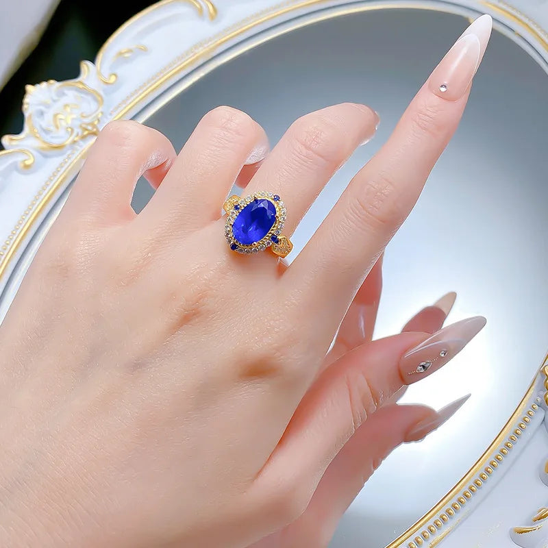 Luxury 24K gold solid ring with blue gemstone, certified, featuring a detailed band and elegant design.