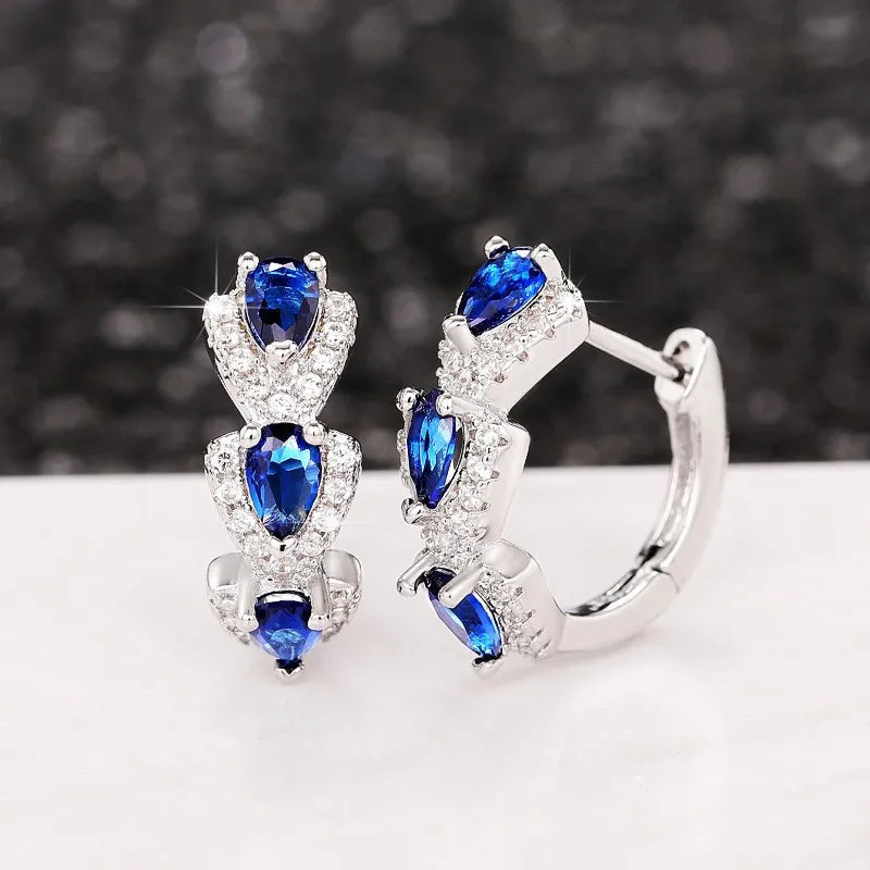 Sterling silver hoop earrings with cubic zirconia from Corporación Turística, showcasing shiny, sparkling jewelry design.
