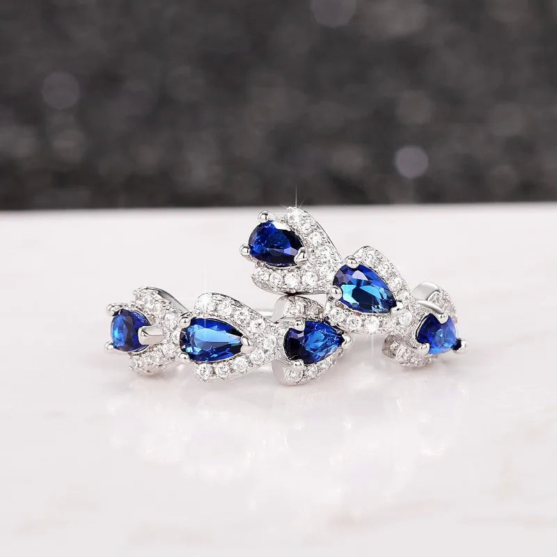 Blue cubic zirconia hoop earrings for women, shiny silver-tone jewelry with a modern circular design.