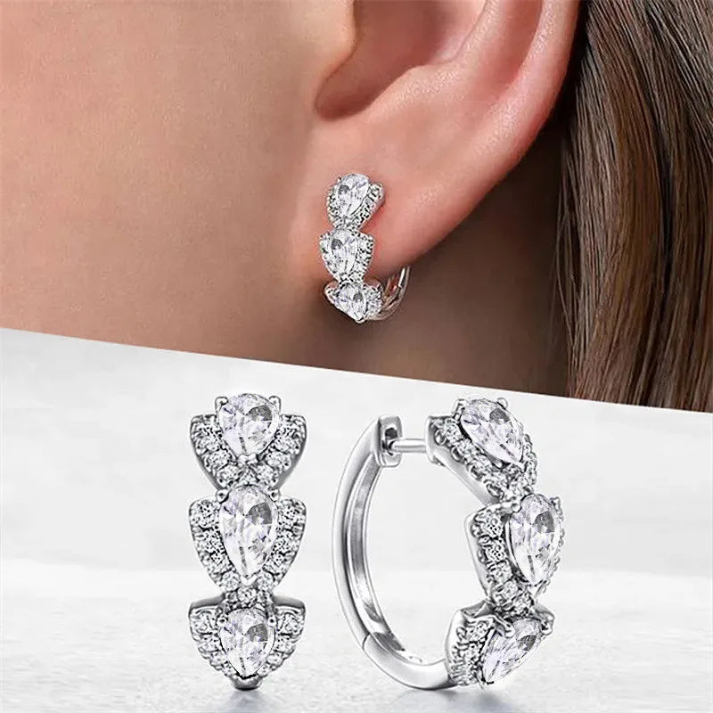 Blue cubic zirconia hoop earrings for women, showcasing shiny, silver-tone metal hoops with vibrant blue stones.