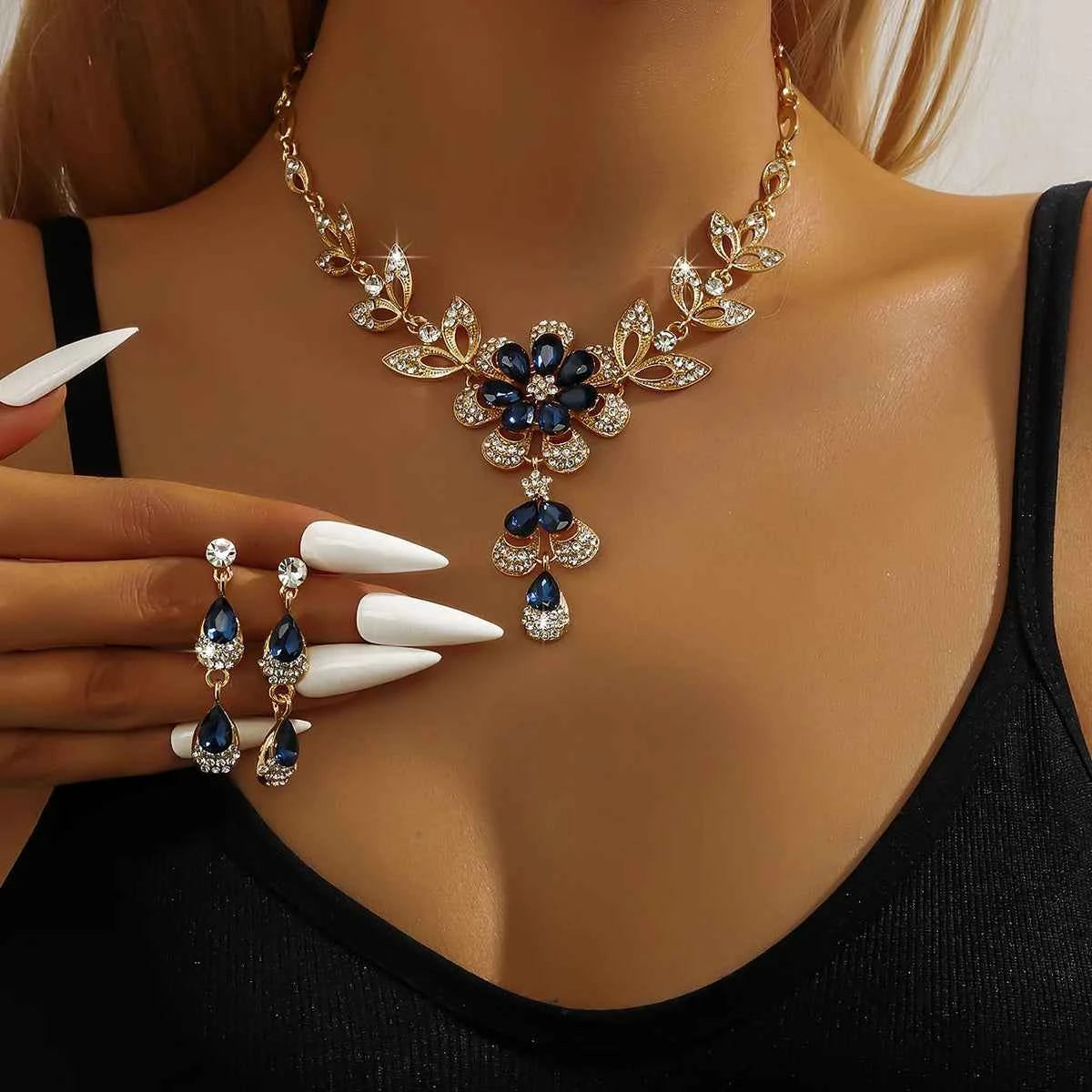 Silver floral jewelry set for women, featuring a gold-tone necklace with flower designs and matching earrings.