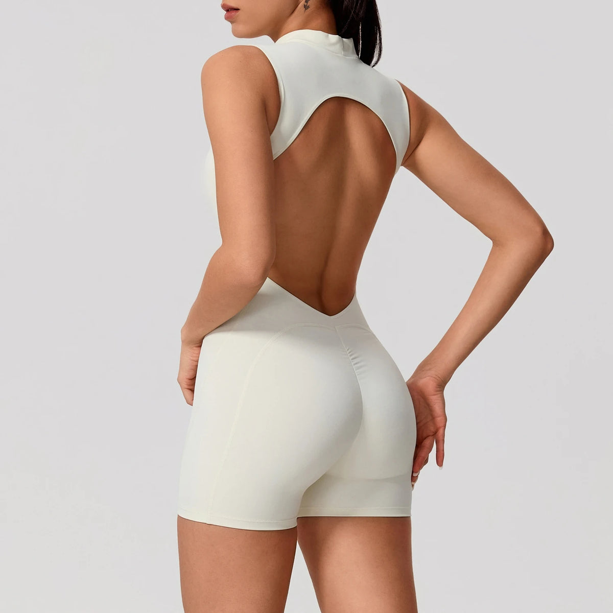 Woman wearing a sleeveless summer sports jumpsuit by Corporación Turística, in apricot color, suitable for active wear.