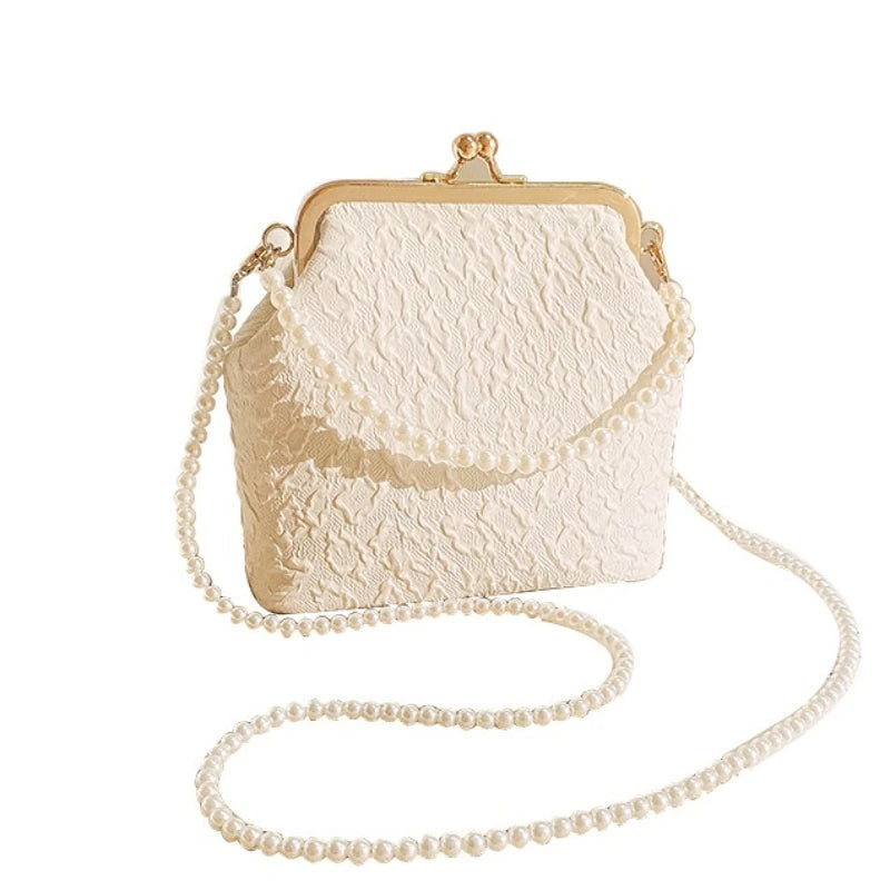 Beige crossbody phone bag with chain from Corporación Turística, featuring a compact design and adjustable strap.