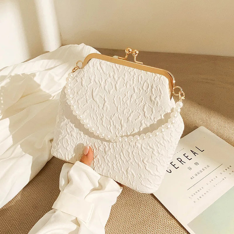 Beige crossbody phone bag with chain from Corporación Turística, featuring a compact design and adjustable strap.