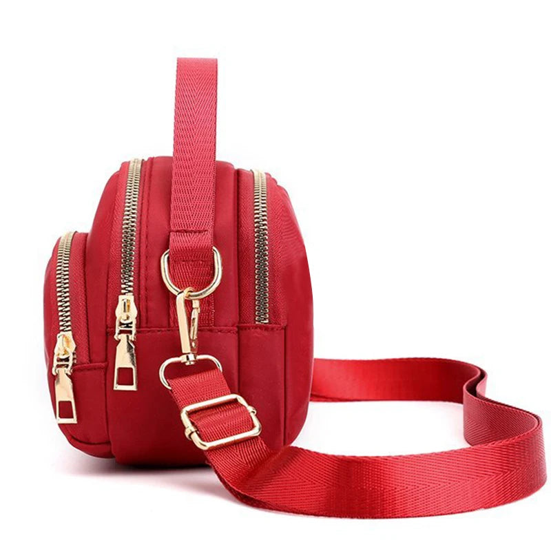 Red versatile, modern shoulder bag for men and women by Corporación Turística, featuring a sleek design and adjustable strap.