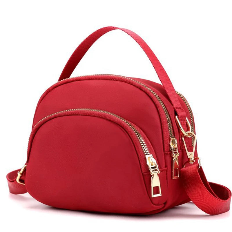 Red modern versatile shoulder bag for men and women by Corporación Turística, with adjustable strap and sleek design.