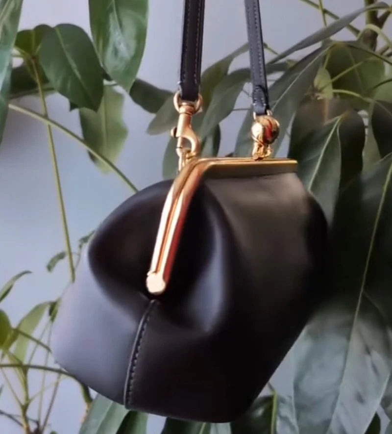 Black classic kiss-lock closure handbag for women, 30 cm length, stylish and elegant, made by Corporación Turística.