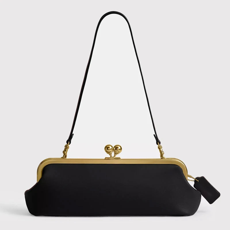 Black classic women's purse with kiss lock closure, 30 cm length, from Corporación Turística, shown in a sleek, elegant design.