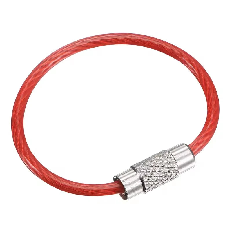 Set of five black stainless steel wire keychains with PVC coating, by Corporación Turística, shown in a close-up image.