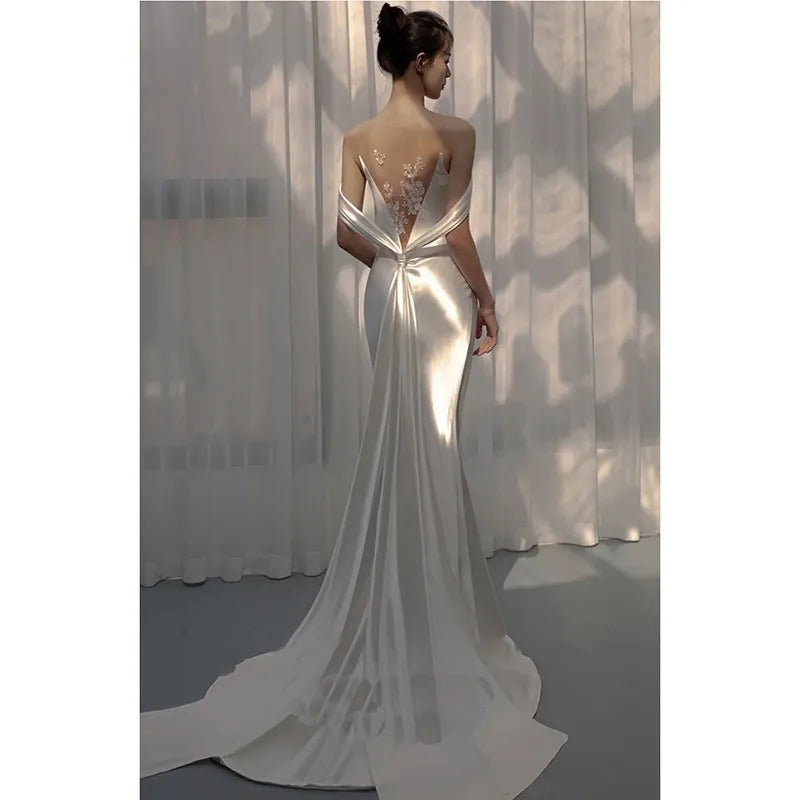 Lightweight backless wedding dress from Corporación Turística with elegant white fabric and delicate design.