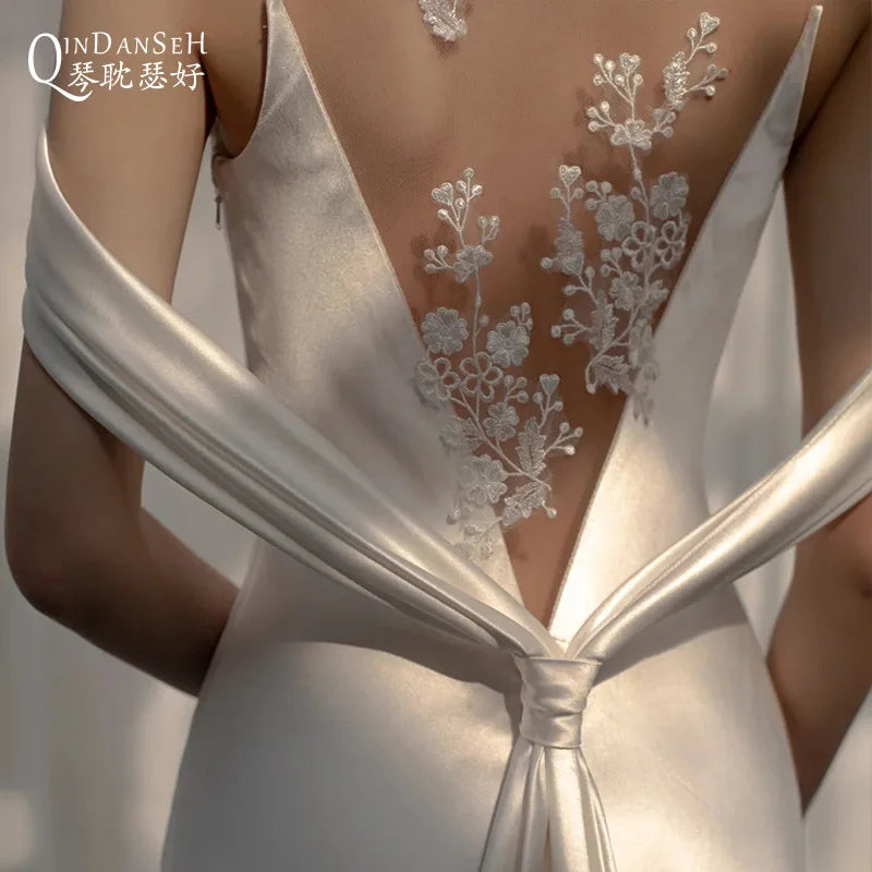 Lightweight backless wedding dress from Corporación Turística featuring elegant white bridal gown with a flowing design.