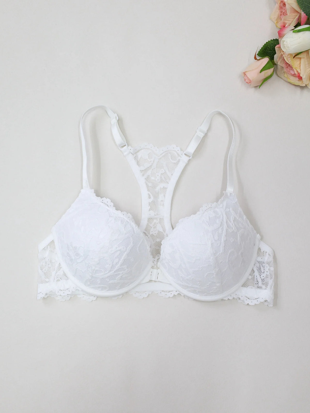 White floral lace women's bra with front closure, featuring adjustable straps and underwire support.