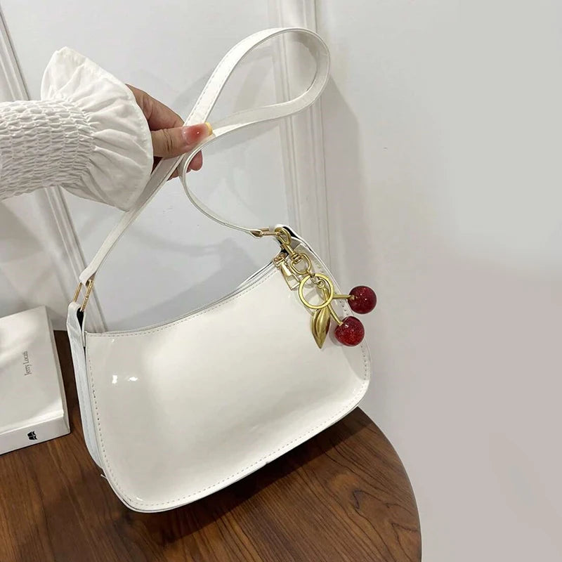 White synthetic leather women's handbag from Corporación Turística, stylish shoulder bag with top handle and elegant design.