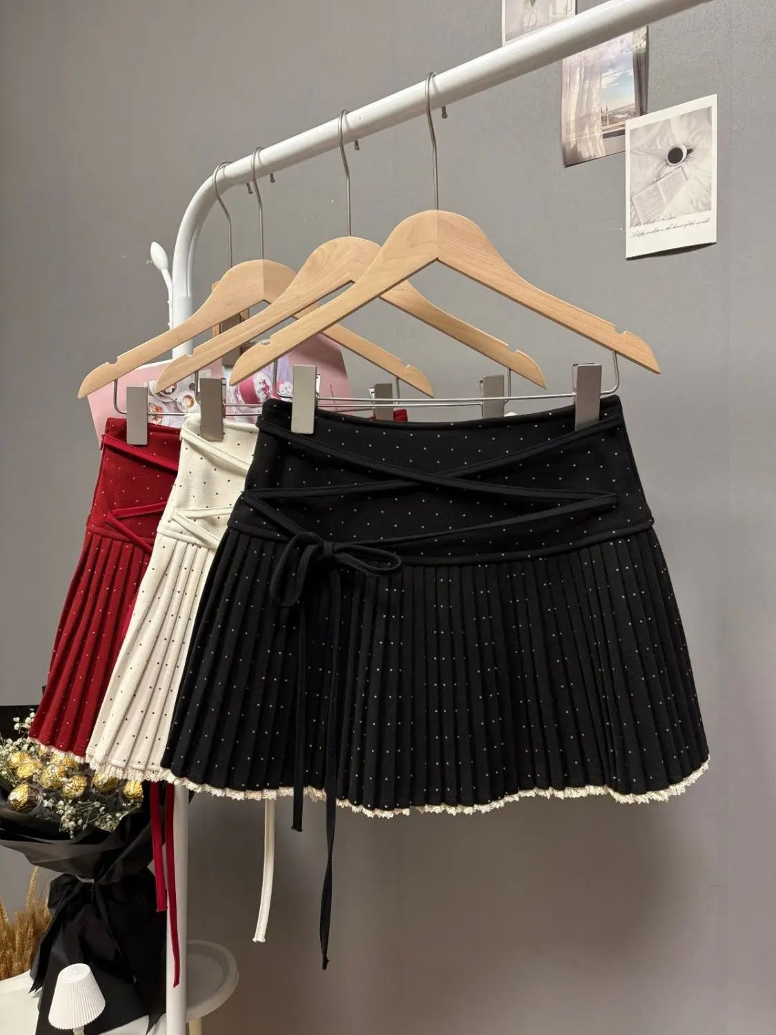 White pleated skirt with crossed polka dot straps from the 2026 Nueva Falda collection by Corporación Turística.