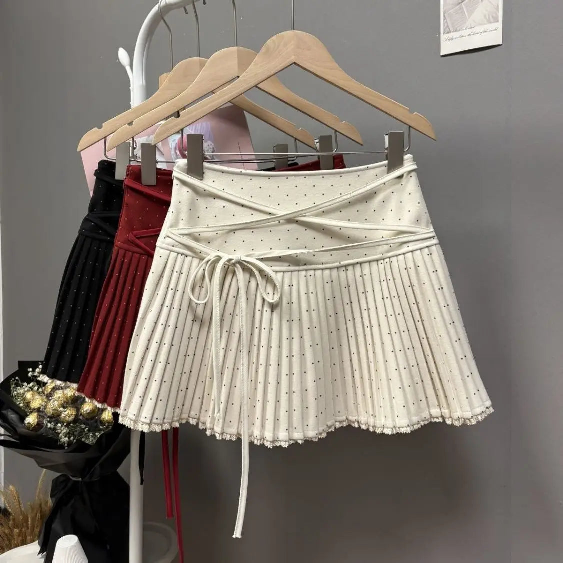 White pleated skirt with crossed polka dot straps, stylish fashion piece from Corporación Turística.